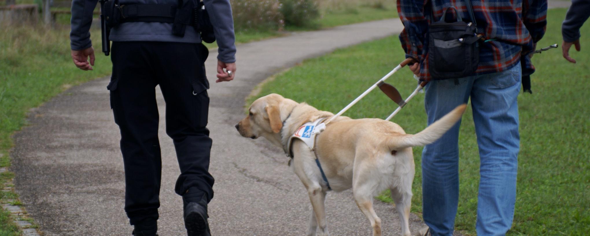 Agent de la police municipale à côté d'un chien d'aveugle
