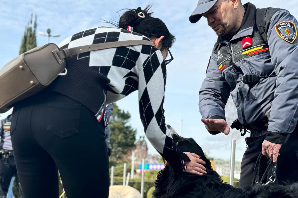 Un agent avec son chien qui discute avec une passante